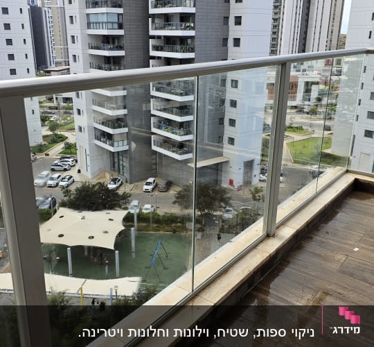 מרפסת עם רצפת עץ רטובה ונוף של בניינים גבוהים
